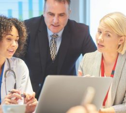 healthcare professionals talking and looking at a laptop
