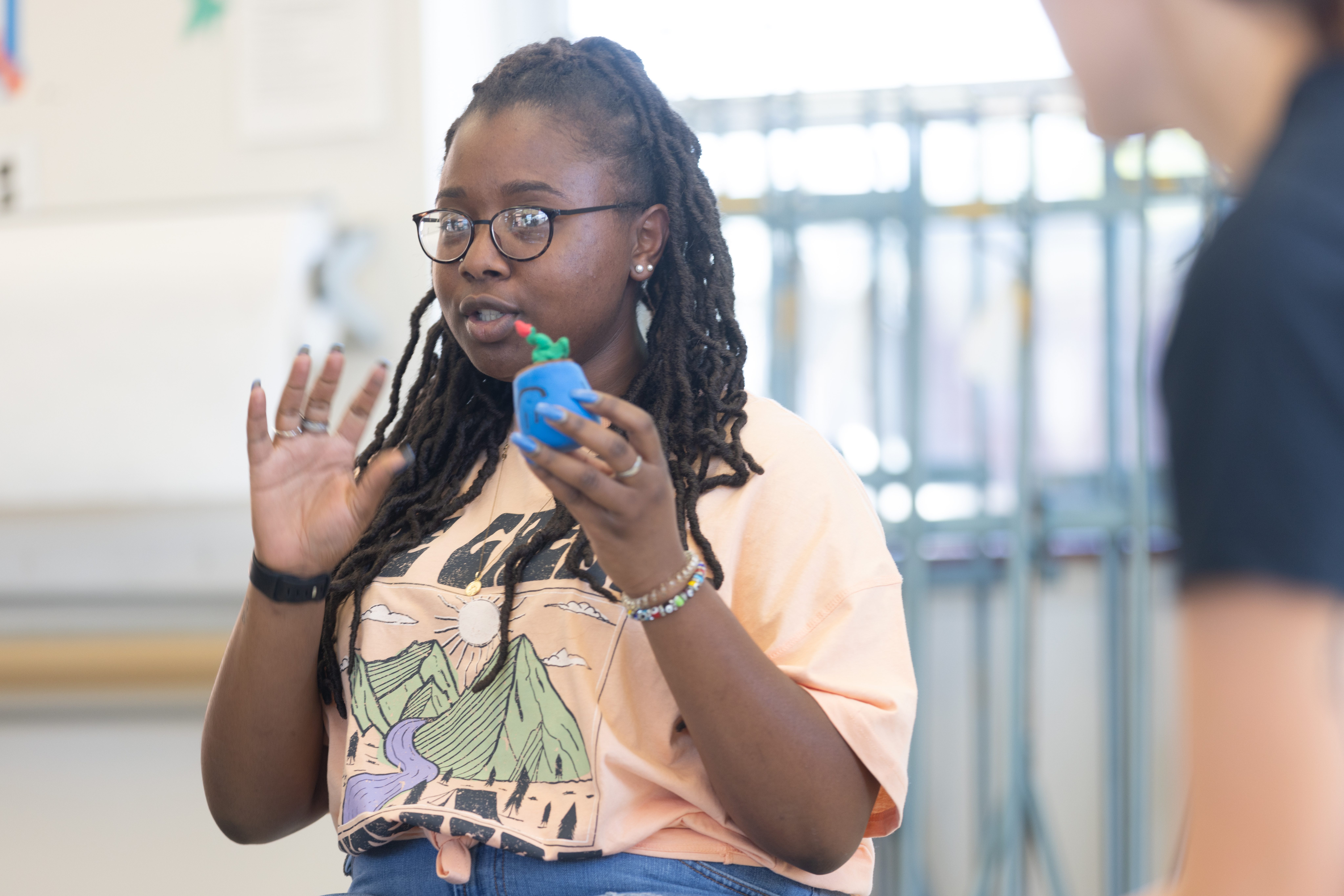 A female student in the arts room holding a clay mold