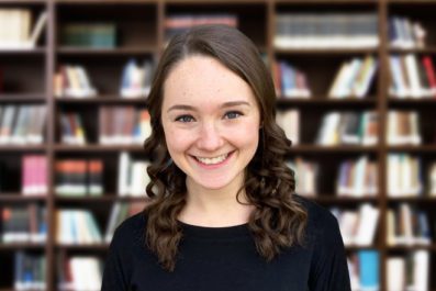 Student in front of Book shelf
