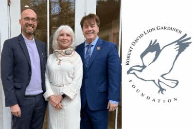 Dean Bowen, Kathryn from the Foundation, and Thomas Flood standing together outside smiling wearing suit jackets and dress