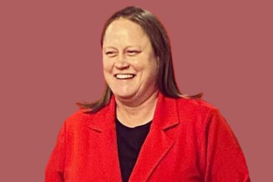 Jackie DiNuzzo smiling wearing red blazer and black shirt