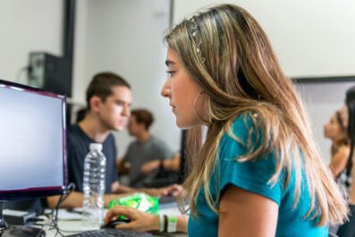 Student seated at computer looking at monitor