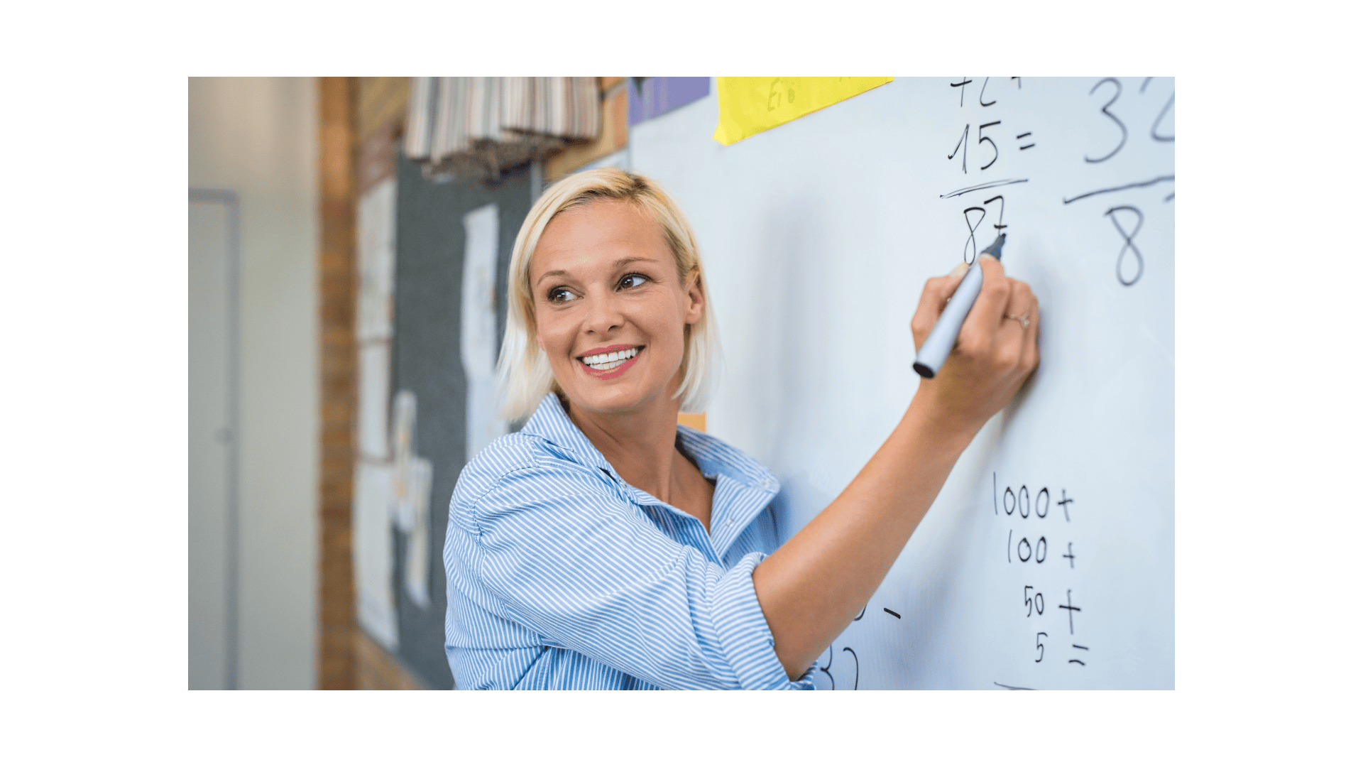 teacher at white board showing elementary school math