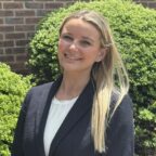 Victoria smiling outside wearing black blazer